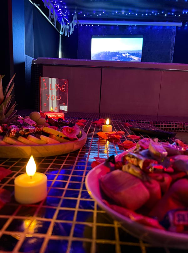 Tilltugg och snacks med ljus och rosblad på bordet